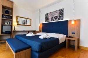 sypialnia z niebieskim łóżkiem i 2 ręcznikami w obiekcie Colleverde Park Hotel w mieście Agrigento