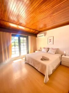 Un dormitorio con una cama grande con techo de madera. en Vila Alice, en Quarteira 34 fotos más