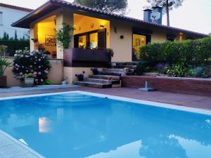 a house with a swimming pool in front of a house at Villa Serena in Santa Cristina d'Aro