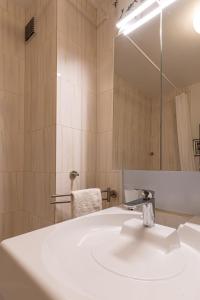 a bathroom with a white sink and a mirror at Appartement deauville place Morny non fumeur in Deauville