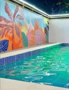 a swimming pool with a painting on the wall at E-Gold Luxury Hotel, Maitama in Abuja