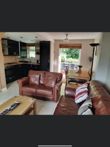 ein Wohnzimmer mit Sofa und Tisch in der Unterkunft SNOWDONIA COTTAGE Glan Gwna Holiday Park in Caernarfon