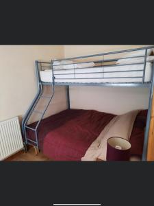 a bedroom with a bunk bed with a red blanket at SNOWDONIA COTTAGE Glan Gwna Holiday Park in Caernarfon +15 photos