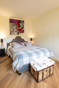 a bedroom with a bed with a blue and white checked bedspread at Appartement deauville place Morny non fumeur in Deauville