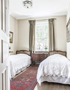 a bedroom with two beds and a window at Köpmansgården Bed & Breakfast in Vellinge