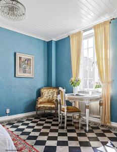 a bedroom with blue walls and a chair and a table at Köpmansgården Bed & Breakfast in Vellinge