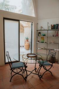レッチェにあるDimora Santangeloのガラステーブルと椅子2脚