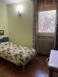 una camera con letto e finestra di B&B Villa Giardini Susanna a Gattico