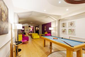 a room with a pool table and colorful chairs at La Clairière bio & spahotel in La Petite-Pierre