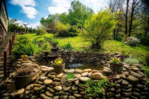 un jardín con una pared de piedra y un estanque en Krokus, en Wisła