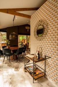 een eetkamer met een bakstenen muur en een spiegel bij ZEN-Bungalow NO 4 met sauna en hottub in Rheezerveen