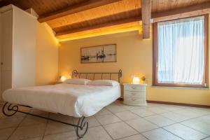 a bedroom with a large bed and a window at Hotel Caneo in Fossalòn
