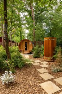 een houten tent in een tuin met een loopbrug bij ZEN-Bungalow NO 4 met sauna en hottub in Rheezerveen
