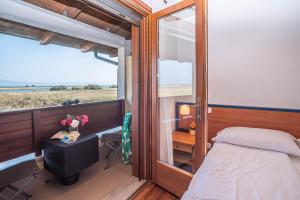 a bedroom with a bed and a window and a desk at Hotel Caneo in Fossalòn