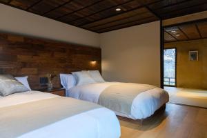 a bedroom with two beds and a window at Hotel mio in Shimabara