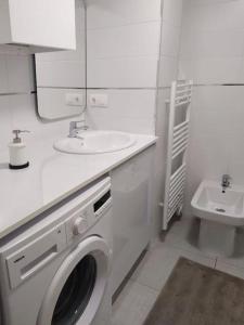 ein weißes Badezimmer mit einer Waschmaschine und einem Waschbecken in der Unterkunft 0143 Apartamento nuevo y céntrico in Vigo