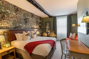 ein Hotelzimmer mit einem Bett und einem Schreibtisch in der Unterkunft The Kings Arms Hotel in Keswick
