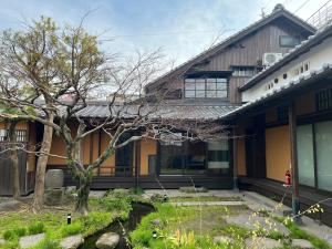 a house with a tree in front of it at Hotel mio in Shimabara