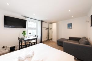 a bedroom with a bed and a couch and a table at Pass the Keys Kings Cross City Nest in London
