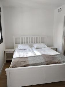 a white bed with two pillows on top of it at Benalmadena new terraced house 3 bedroom 2,5 bathroom in Benalmádena