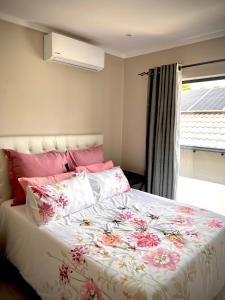 a bedroom with a large bed with a floral comforter at No Load-Shedding Holiday Home in Mataffin