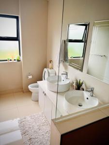 a bathroom with two sinks and a toilet at No Load-Shedding Holiday Home in Mataffin