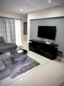 a living room with a flat screen tv on a wall at No Load-Shedding Holiday Home in Mataffin