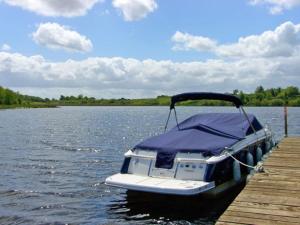 a small boat tied to a dock on a lake at Fermanagh Holiday Home in Newtown Butler