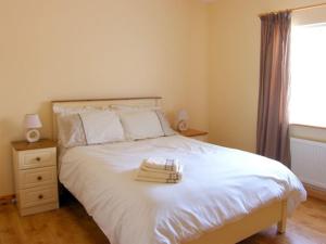 sypialnia z białym łóżkiem i ręcznikami w obiekcie Fermanagh Holiday Home w mieście Newtown Butler