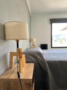 eine Lampe auf einem Nachttisch neben einem Bett in der Unterkunft Hábitat 268 in Esquel