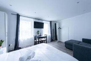 a bedroom with a bed and a couch and a table at Pass the Keys Kings Cross City Escape in London