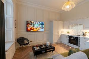 a living room with a tv on a wall at The Devonshire Suite - Your 5 STAR West End Stay! in Glasgow