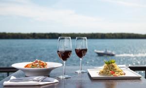 - une table avec deux verres de vin et une assiette de nourriture dans l'établissement Niagara Riverside Resort; BW Premier Collection, à Niagara Falls