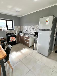 a kitchen with a stainless steel refrigerator and a table at Hábitat 268 in Esquel