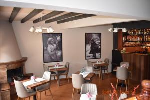 Hotel Meteora في كالامباكا: مطعم بطاولات وكراسي ومدفأة