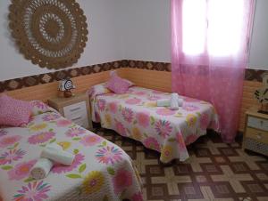 a bedroom with two beds and a mirror at Conjunto Rural Andrea in Moriles