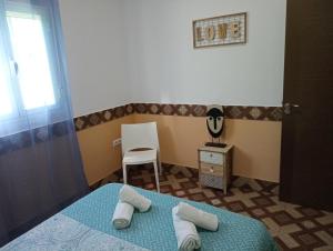 1 dormitorio con 1 cama con toallas en Conjunto Rural Andrea, en Moriles