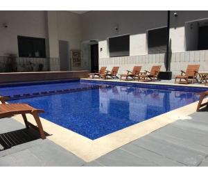een groot zwembad met stoelen en blauw water bij Residence miramar in Mohammedia