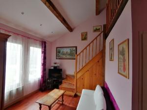 a living room with a staircase and a table at L'Odyssée VILLA ILOA in Dommartemont