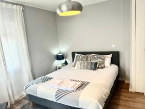 niewielka sypialnia z łóżkiem z białą pościelą i poduszkami w obiekcie Casa do Moleiro w mieście Amarante