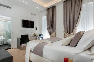 a white bedroom with a large bed and a bathroom at Vatican Style in Rome