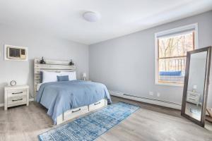 a white bedroom with a bed and a mirror at Luxury 3Bed Private Apartment Near Manhattan in New Rochelle