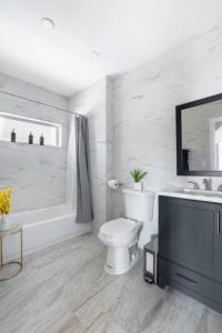een witte badkamer met een toilet en een wastafel bij Luxury 3Bed Private Apartment Near Manhattan in New Rochelle