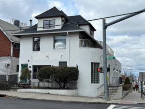 a white house on the corner of a street at Luxury 3Bed Private Apartment Near Manhattan in New Rochelle
