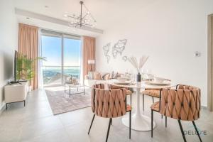 biała jadalnia ze stołem i krzesłami w obiekcie Cosmopolitan 2BR at Stella Maris Dubai Marina by Deluxe Holiday Homes w Dubaju