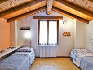 1 dormitorio con 2 camas y ventana en Lovely holiday home in Valbondione with balcony, en Valbondione