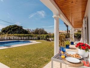 a table with plates of food on it next to a pool at Fantastic four-bedroom villa in Praia da Luz with private pool in Caliços