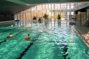 eine Gruppe von Personen, die in einem Schwimmbad schwimmen in der Unterkunft Panoramic App C02-1 in Sierksdorf