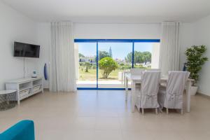 a dining room with a table and a large window at Apartamentos Clube da Bemposta in Alvor
