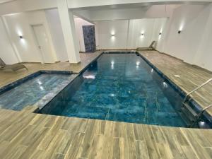 una piscina de agua azul y suelos de madera en Studio Très Moderne Gallo 1 - Mamelles Dakar, en Dakar
